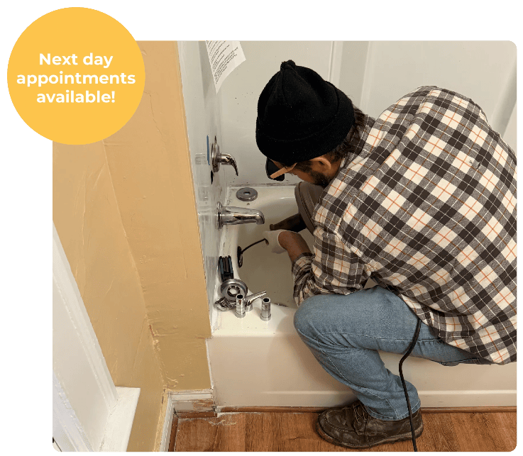 Cleveland Drain Cleaning Service Plumbird plumber snaking a clogged bathtub drain in a Cleveland home